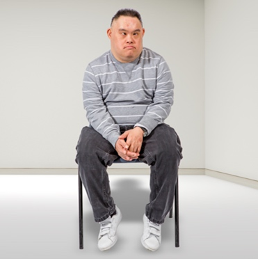 A young man sitting alone in an empty room
