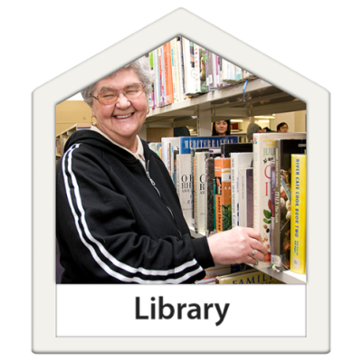 A woman choosing a book from a bookcase at the library