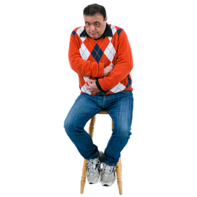 A man sitting on a stool clutching his stomach