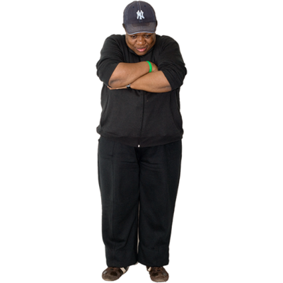 A woman looking at the floor with her arms crossed