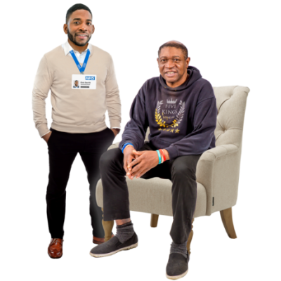 A man sitting in an armchair with a doctor standing next to him