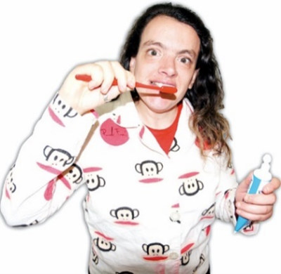 A young woman in pyjamas brushing her teeth